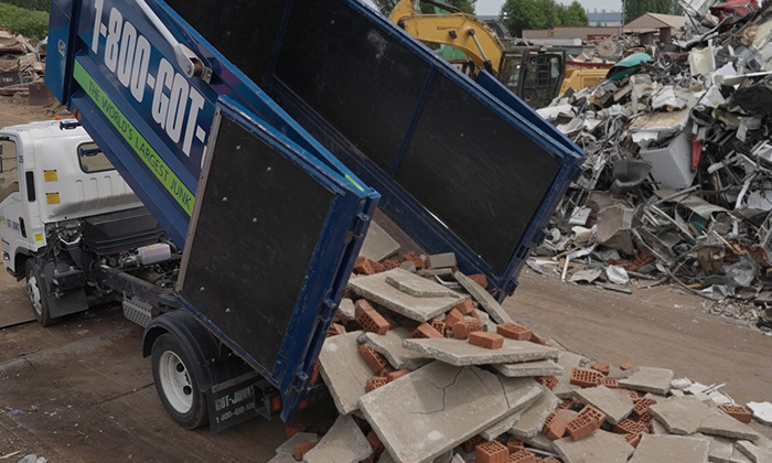 1-800-GOT-JUNK? truck team disposing of concrete.