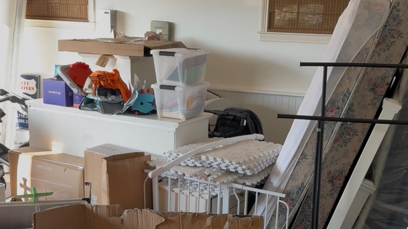 Moving boxes, old furniture, and random clutter in a garage