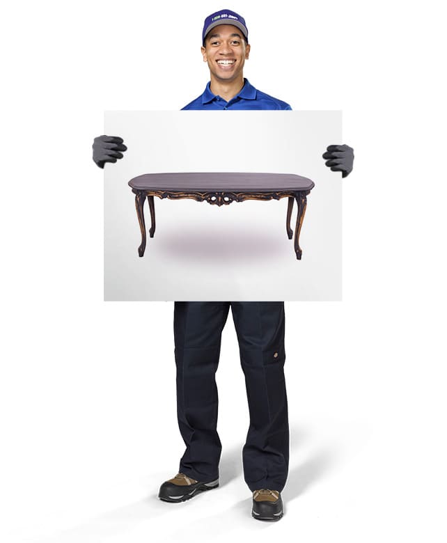 1-800-GOT-JUNK? Truck Team Member holding an image of a coffee table