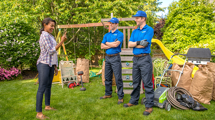 1-800-GOT-JUNK? team with a lawn mower for pick up in front of a customer