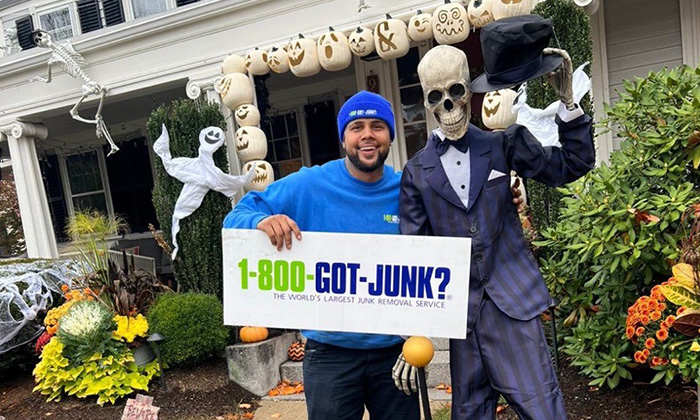 A 1-800-GOT-JUNK? Truck Team Member by a skeleton.