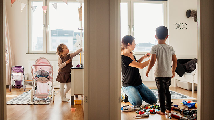 Mother and two children searching through toys to donate