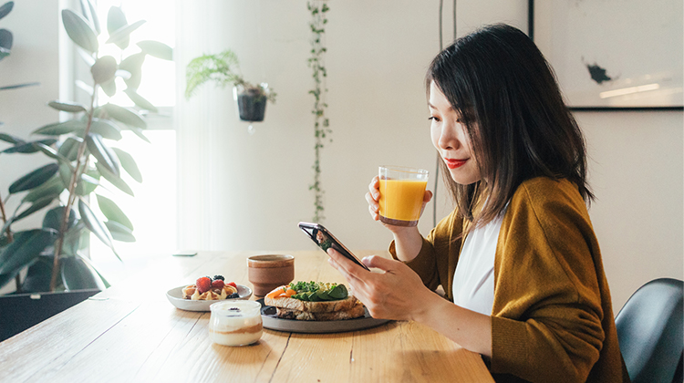 Woman having brunch while looking at her phone