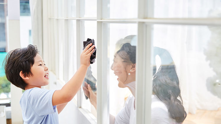 Mother and son cleaning windows together 